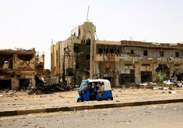 People pass by damaged cars and buildings at the central market during clashes between the paramilitary Rapid Support Forces and the army in Khartoum, Sudan, April 27, 2023. (Reuters Photo)